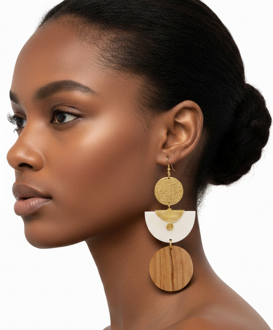 Woman wearing gold and white earrings on a white background