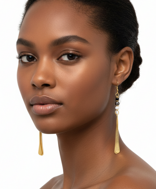 Woman wearing gold earrings with a plain background