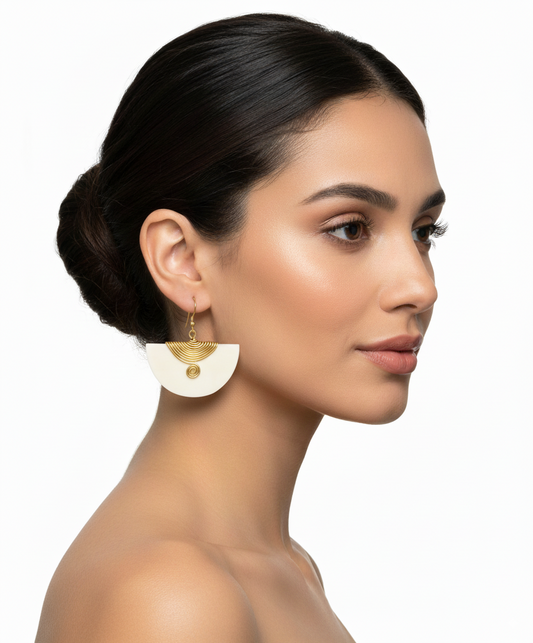 Woman wearing gold earrings with a white background
