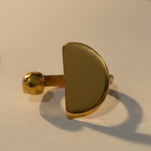 Gold ring on a light surface with a blurred background