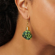 A woman wearing a green and lime colored beaded earring.
