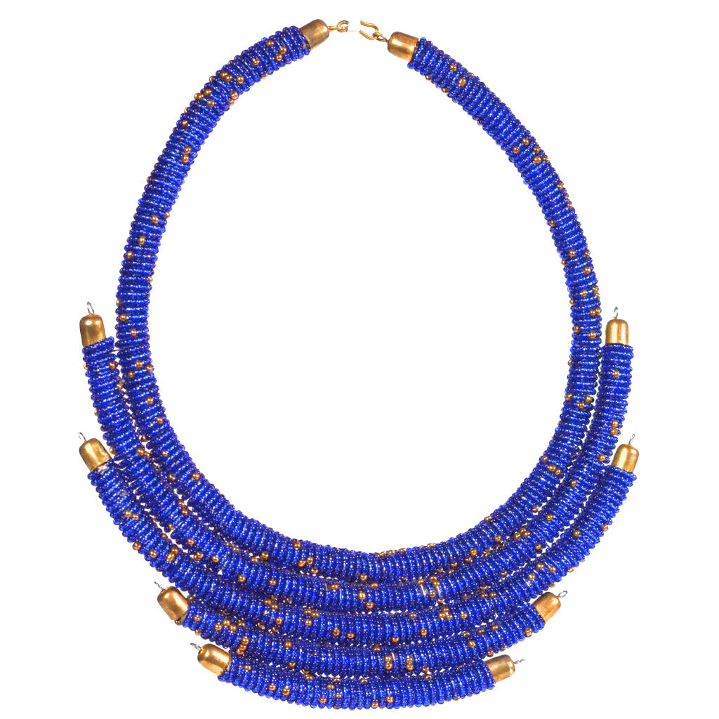 A woman wearing a beaded necklace with gold-tone accents and a wide hook for closure.