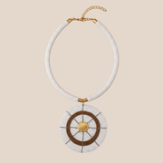 Necklace with white beads and gold accents on a beige background