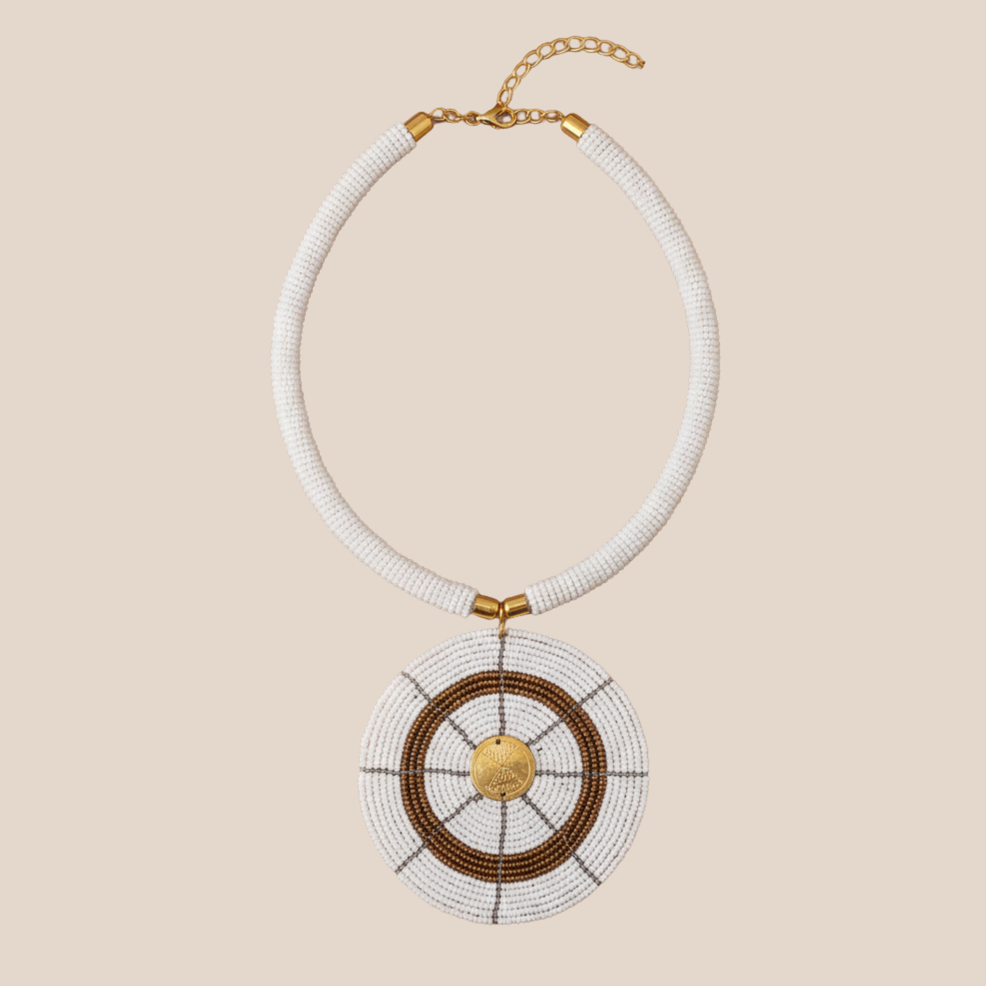 Necklace with white beads and gold accents on a beige background