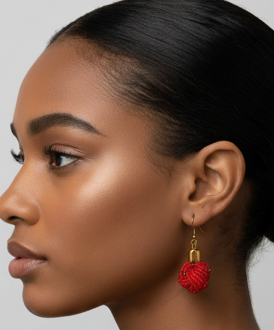 Woman with a bun wearing red earrings against a neutral background