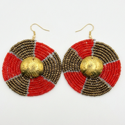 Pair of earrings with red and gold design on a white background
