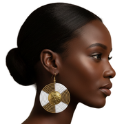 Woman wearing large beaded earrings on a white background