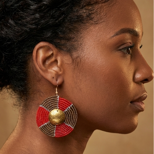 Woman wearing large earring with a red and gold design on a beige background