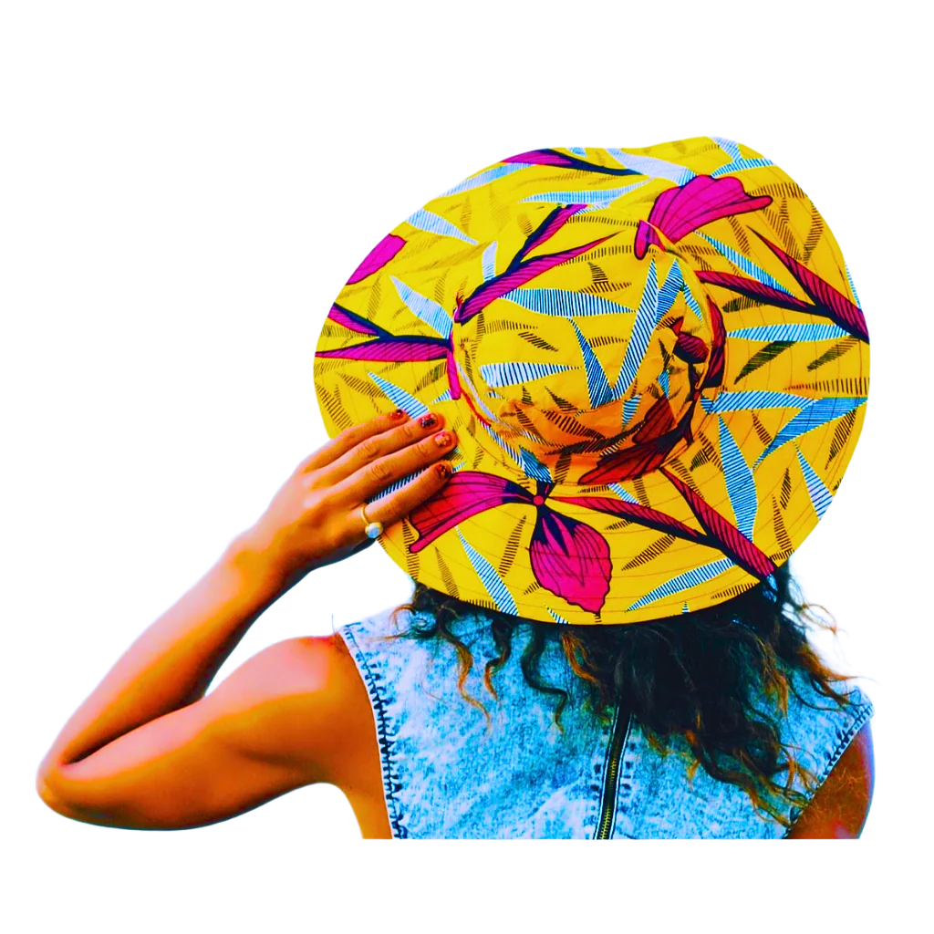 A back view of a woman wearing a colorfully patterned yellow and pink sun hat in a white background.