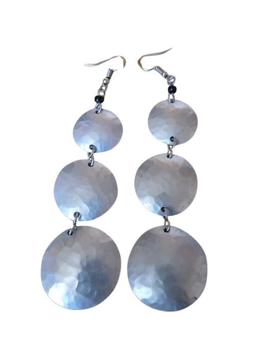 This image displays a pair of elegant silver earrings, crafted with a series of three graduated, circular discs. Each disc is meticulously crafted from aluminum, showcasing a stunning shimmering silver finish that captures light, creating a dazzling effect.