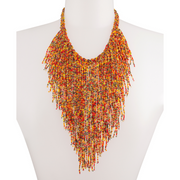 A mannequin wearing an orange beaded necklace accented with various colorful beads like red, yellow, and gold.