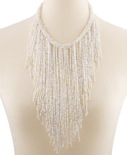 A mannequin wearing a white beaded necklace.