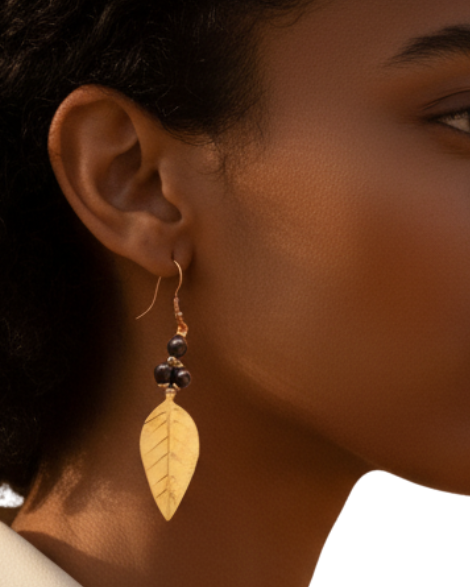 Woman wearing a white blouse with a close-up of her leaf-shaped earrings.