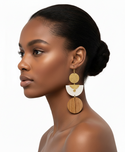 Woman wearing gold and white earrings on a white background