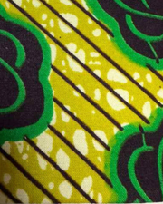 A swatch of a colorful fabric with green & yellow